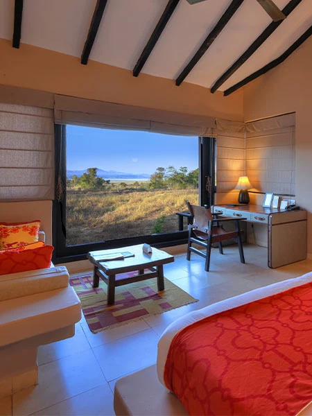 Interior view of a luxury cottage room with large window overlooking Satpura landscape